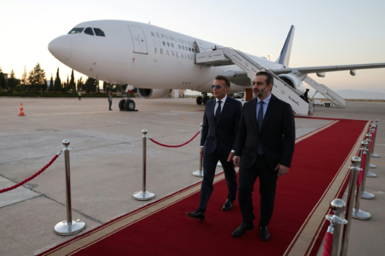 Le président français Emmanuel Macron (g) est accueilli par le ministre syrien des Affaires étrangères Assaad al-Chaibani (d) à son arrivée à l'aéroport international de Damas, pour une visite d'État, le 6 juillet 2026 en Syrie ( AFP / Ludovic MARIN )