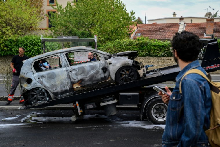 Une voiture brûlée lors d'une manifestation de lycéens devant le lycée André Cuzin à Caluire-et-Cuire, près de Lyon, le 30 septembre 2026 ( AFP / OLIVIER CHASSIGNOLE )