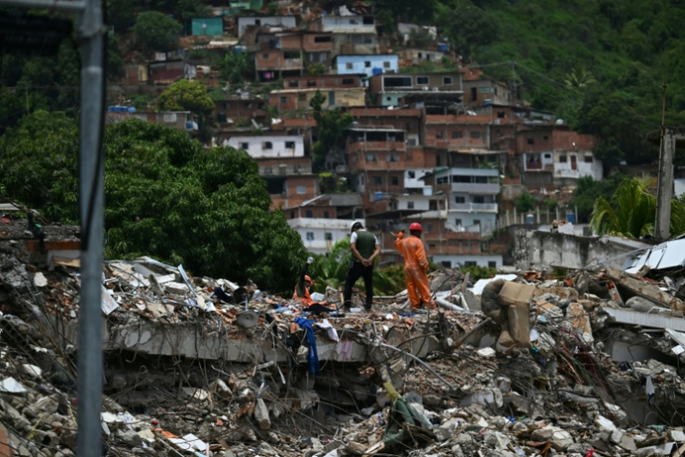 Des sauveteurs recherchent des victimes dans les décombres d'un bâtiment effondré à Caraballeda, dans l'Etat de la Guaira, le 30 juin 2026 au Venezuela ( AFP / Juan BARRETO )