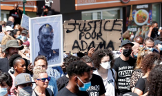 Des personnes portant des masques de protection assistent à une marche en mémoire d'Adama Traoré