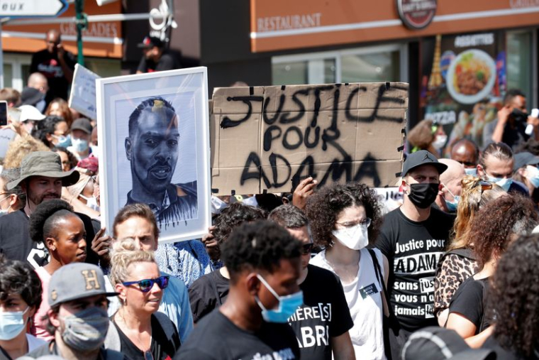 Des personnes portant des masques de protection assistent à une marche en mémoire d'Adama Traoré
