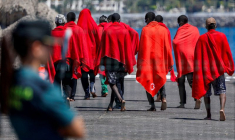Des migrants se dirigent vers une tente de la Croix-Rouge après avoir débarqué d'un navire des garde-côtes espagnols, dans le port d'Arguineguin.