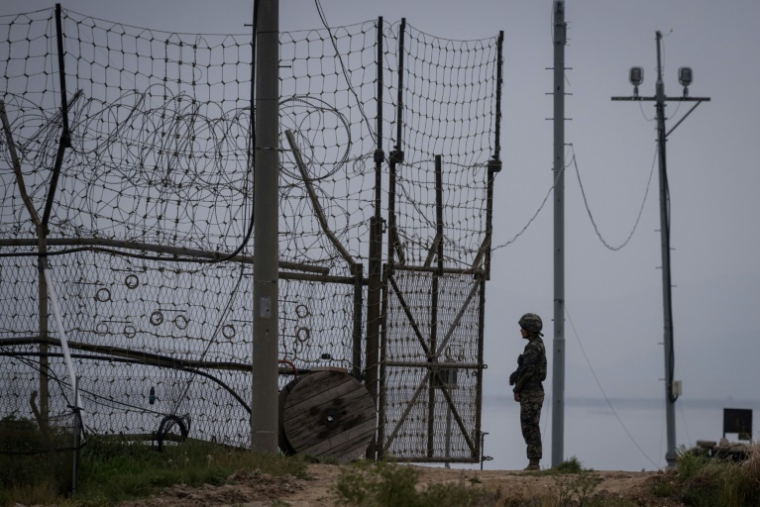 Un soldat sud-coréen monte la garde devant une ouverture de la clôture de la DMZ, à Gyodong, le 9 mai 2017 ( AFP / Ed JONES )
