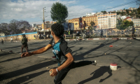 Un manifestant lance une pierre vers des membres des forces de sécurité le 4 octobre 2025 à Antananarivo ( AFP / RIJASOLO )