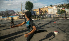 Un manifestant lance une pierre vers des membres des forces de sécurité le 4 octobre 2025 à Antananarivo ( AFP / RIJASOLO )