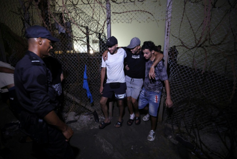 Des migrants regagnent Fnideq, la ville marocaine qui jouxte l'enclave espagnole de Ceuta où des milliers de candidats marocains à l'émigration ont afflué ces derniers jours, le 1er août 2026  ( AFP / Abdel Majid BZIOUAT )