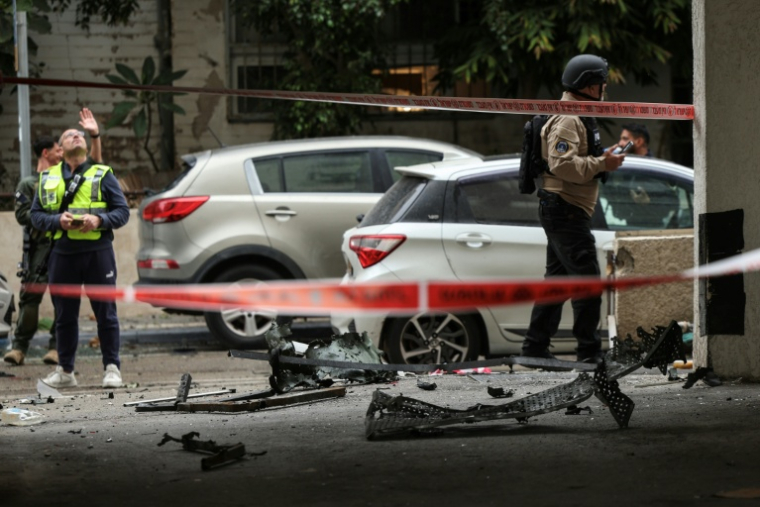 Des membres forces de sécurité israéliennes et des secouristes sur le site d'un impact dans un quartier résidentiel de Tel-Aviv après une frappe iranienne, le 1er avril 2026 ( AFP / Jack GUEZ )