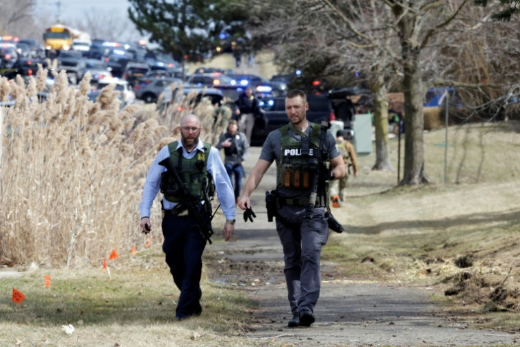 Des policiers armés sur Walnut Lake Rd alors que les forces de l'ordre interviennent sur les lieux d'une fusillade à la synagogue Temple Israel de West Bloomfield, Michigan, une banlieue de Détroit, le 12 mars 2026 ( AFP / JEFF KOWALSKY )