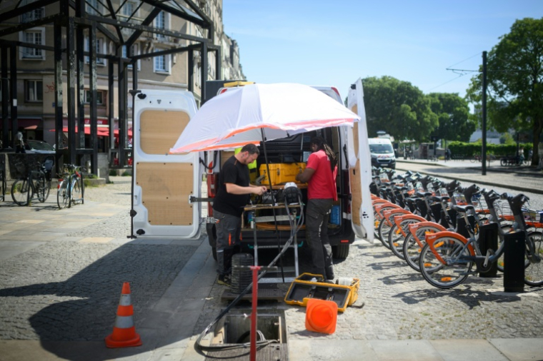 Des ouvriers se protègent de la chaleur sous un parasol à Nantes le 26 mai 2026 ( AFP / Loic VENANCE )