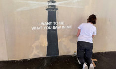 Agnès Perrone, peintre en décor du patrimoine, répare une œuvre d'art de l'artiste de rue Banksy représentant un phare sur la façade d'un bâtiment, après qu'elle a été vandalisée pendant la nuit à Marseille, le 1er juin 2025 ( AFP / Viken KANTARCI )