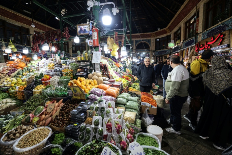 Des clients autour d'un étal du bazar Tajrish à Téhéran le 29 décembre 2025. ( AFP / ATTA KENARE )