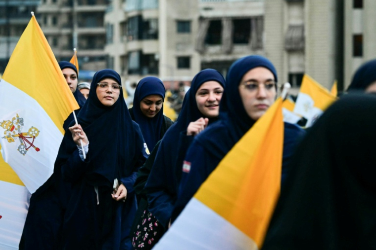 Des femmes musulmanes libanaises tiennent des drapeaux du Vatican en attendant l'arrivée du pape Léon XIV dans la banlieue sud de Beyrouth, un quartier résidentiel connu sous le nom de Dahiyeh, bastion du Hezbollah, le 30 novembre 2025 au Liban ( AFP / Giuseppe CACACE )