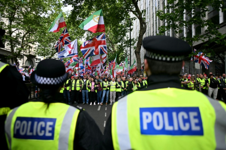 Des policiers face à des partisans de Tommy Robinson, militant d'extrême droite britannique, rassemblés pour une marche organisée par Unite The Kingdom, le 16 mai 2026 à Londres ( AFP / JUSTIN TALLIS )