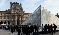 Des visiteurs font la queue devant la Pyramide du Louvre, conçue par l'architecte sino-américain Ieoh Ming Pei, et le musée du Louvre le jour de sa réouverture après un vol de bijoux, le 22 octobre 2025 à Paris ( AFP / Thibaud MORITZ )