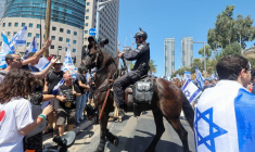 Des manifestants font un geste en direction d'un policier israélien lors de la "Journée de perturbation" à Tel Aviv, Israël