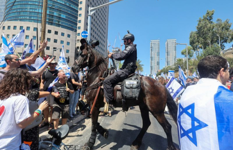 Des manifestants font un geste en direction d'un policier israélien lors de la "Journée de perturbation" à Tel Aviv, Israël