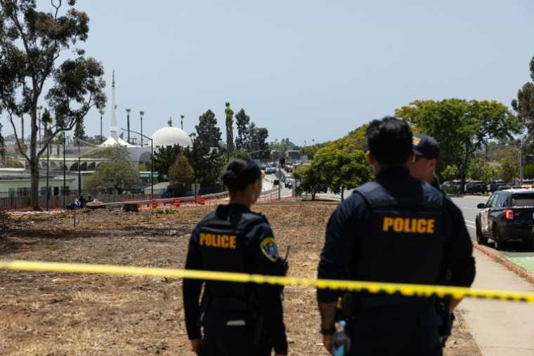 Deux membres des forces de l'ordre près de la mosquée de San Diego, en Californie, où trois personnes ont été tuées et où les deux tireurs présumés ont été retrouvés morts, le 18 mai 2026 ( AFP / Zoë Meyers )