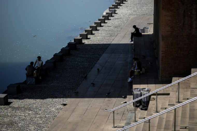 Des personnes s'abritent du soleil à l'ombre d'un pont à Toulouse le 11 août 2025 ( AFP / Lionel BONAVENTURE )