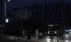 Des piétons traversent une rue sans éclairage à Tcherniguiv (Ukraine), le 22 octobre 2025, après une frappe russe contre une infrastructure énergétique de la région ( AFP / Andrew Kravchenko )