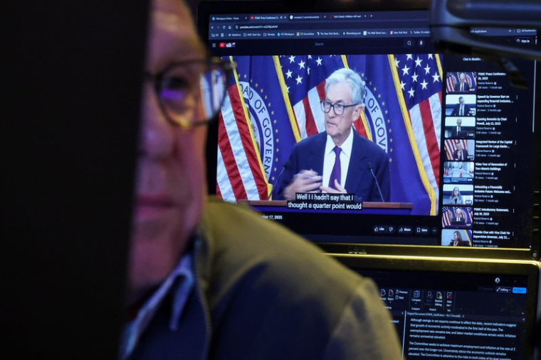 Un trader travaille, alors qu'un écran diffuse une conférence de presse du président de la Réserve fédérale américaine Jerome Powel
