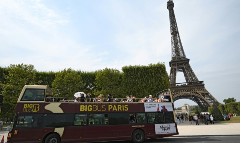 Un car de touristes à Paris, le 13 août 2025 ( AFP / Bertrand GUAY )