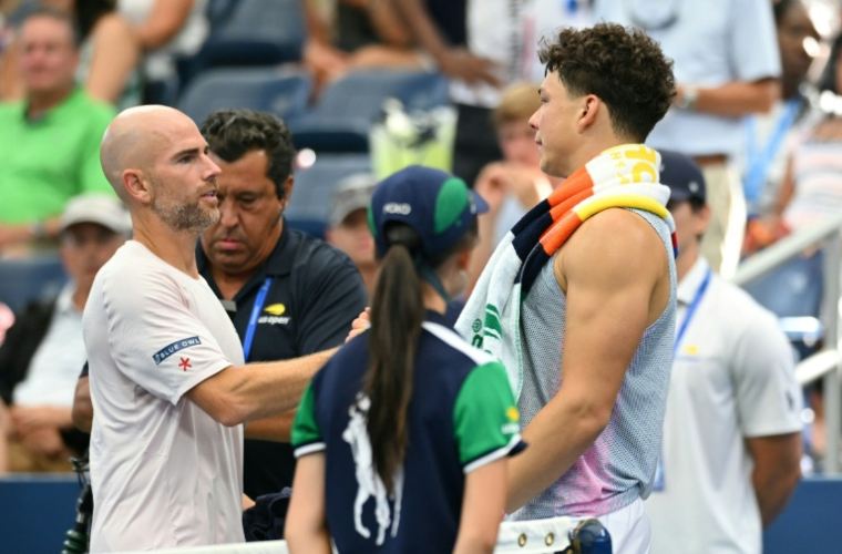 Ben Shelton (à droite) et le Français Adrian Mannarino après l'abandon sur blessure de l'Américain au troisième tour de l'US Open le 29 aoîut 2025 à New York ( AFP / ANGELA WEISS )