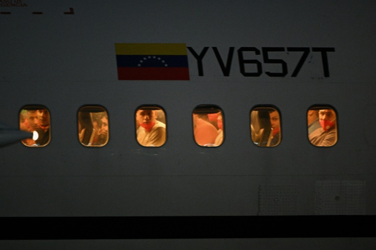 Des migrants vénézuéliens emprisonnés au Salvador regardent par les hublots de l'avion alors qu'il atterrit à l'aéroport international Simon Bolivar de Maiquetia, au Venezuela, le 18 juillet 2025 ( AFP / Federico PARRA )