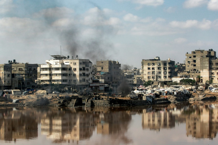 Des tentes abritant des déplacés au milieu des destructions et d'un bassin de traitement des eaux usées dans la ville de Gaza, le 14 juillet 2025 ( AFP / Bashar TALEB )