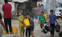 Des enfants palestiniens portent un bidon rempli d'eau potable à partir de citernes mobiles dans le camp de réfugiés de Bureij, dans le centre de la bande de Gaza, le 6 octobre 2025 ( AFP / Eyad BABA )