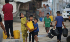 Des enfants palestiniens portent un bidon rempli d'eau potable à partir de citernes mobiles dans le camp de réfugiés de Bureij, dans le centre de la bande de Gaza, le 6 octobre 2025 ( AFP / Eyad BABA )
