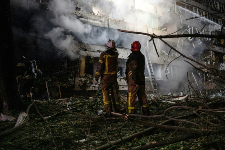 Des pompiers sur le site d'une frappe de missile russe contre un immeuble résidentiel à Kiev, le 14 octobre 2026 en Ukraine ( AFP / Genya SAVILOV )