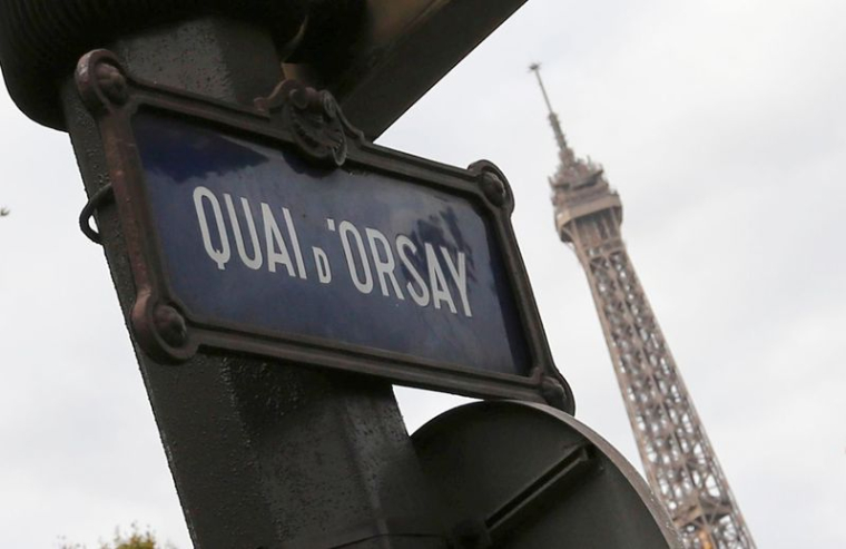 Un panneau de rue indiquant "Quai d'Orsay" est visible près de la tour Eiffel à Paris