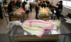 Des étudiants s'entraînent sur un mannequin au rite de  la mise en bière dans une salle de classe de l'Institut des sciences et technologies de Busan, dans le sud-est de la Corée du Sud, le 24 septembre 2025 ( AFP / Jung Yeon-je )