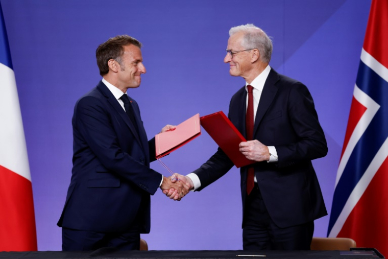 Le président français Emmanuel Macron (g) et le Premier ministre norvégien Jonas Gahr Støre se serrent la main après avoir signé des accords lors d'un événement sur la décarbonisation industrielle au Musée national d'Oslo, en Norvège, le 23 juin 2025 ( AFP / Odd ANDERSEN )