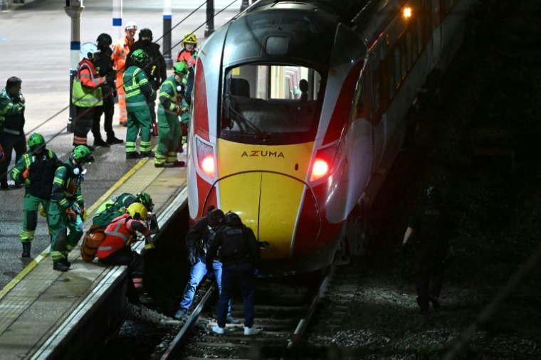 Policiers et secouristes inspectent des voies en gare de Huntingdon après une attaque à l'arme blanche qui a fait au moins 10 blessés dont neuf graves dans un train en direction de Londres, dans l'est de l'Angleterre, le 1er novembre 2025 ( AFP / JUSTIN TALLIS )