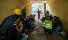 Des personnes secourues, des journalistes et des policiers se mettent à l'abri alors qu'une sirène d'alerte aérienne retentit lors d'une frappe de drone russe à Kiev, Ukraine