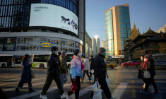 Des personnes portant des masques de protection traversent une rue à Shanghai