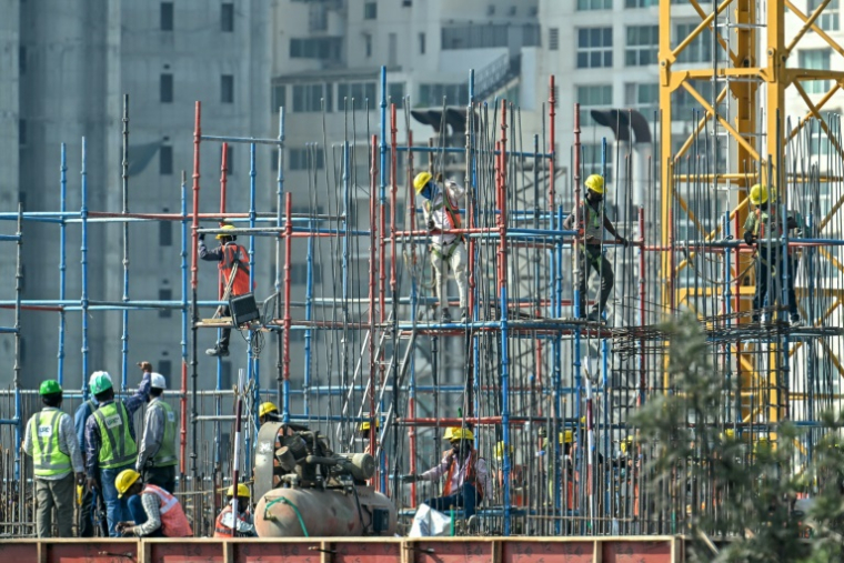 Des travailleurs sur un immeuble en construction à Bengaluru, en Inde, le 27 février 2025 ( AFP / Idrees MOHAMMED )