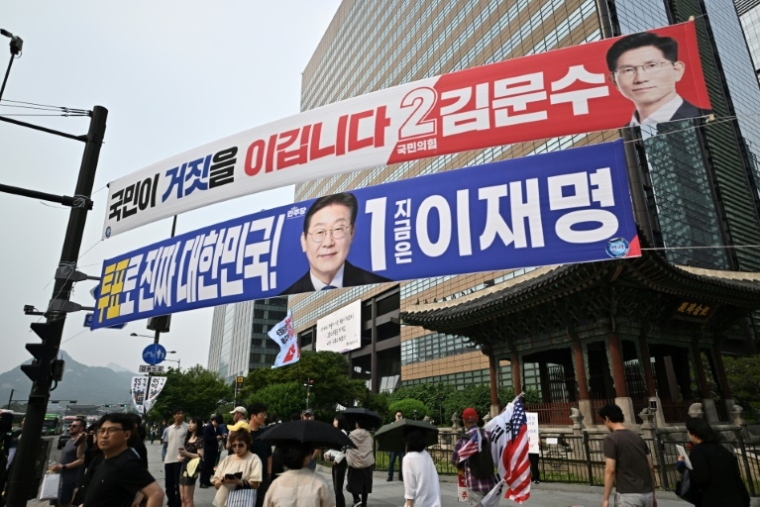 Des banderoles montrant Kim Moon-soo, le candidat à la présidence du Parti du Pouvoir au peuple (en haut, en rouge), et Lee Jae-myung, le candidat à la présidence du Parti démocrate (en bleu), quelques jours avant l'élection présidentielle du 3 juin à Séoul, le 31 mai 2025 ( AFP / Pedro PARDO )
