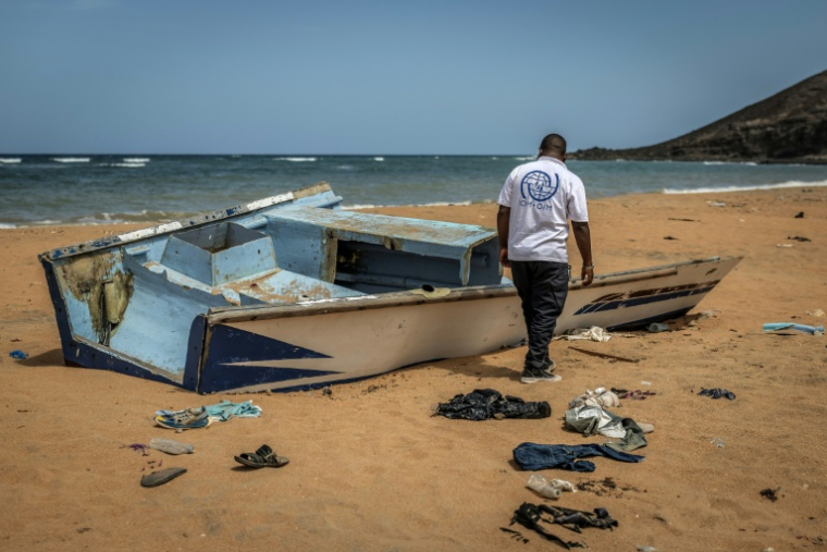 Un membre de l'Organisation internationale pour les Migrations (OIM), sur la plage de Gehere à Djibouti, près des restes d'une embarcation transportant des migrants et ayant fait récemment naufrage ( AFP / Luis TATO )