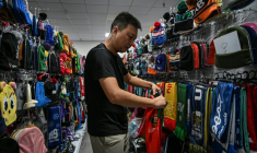 Shang Yabing, le directeur, trie des produits dans une salle d'exposition d'une usine qui produit des chapeaux et des écharpes à Yiwu, dans la province du Zhejiang, dans l'est de la Chine, le 18 septembre 2025 ( AFP / Jade GAO )