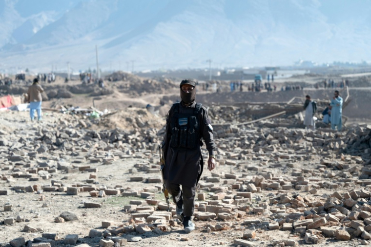 Un membre des forces de sécurité talibanes sur le site d'une frappe aérienne pakistanaise, en périphérie de Kaboul, le 13 mars 2026 en Afghanistan ( AFP / Wakil KOHSAR )
