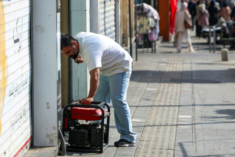 Un homme démarre un générateur pour alimenter son magasin lors d'une à Téhéran, le 1er septembre 2025 en Iran ( AFP / - )