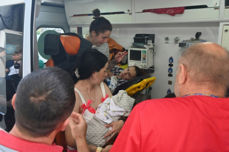 Du personnel médical évacue des mères et leurs nouveau-nés, ainsi que des patients d'une maternité endommagée après une attaque de drone russe dans le centre de Kharkiv, le 11 juillet 2025 en Ukraine ( AFP / SERGEY BOBOK )
