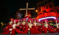 Les danseuses du Moulin Rouge se produisent sous les nouvelles ailes du cabaret pour célébrer leur remise en service, le 10 juillet 2025 à Paris ( AFP / Dimitar DILKOFF )