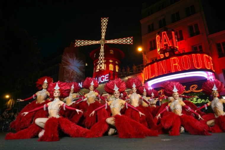 Les danseuses du Moulin Rouge se produisent sous les nouvelles ailes du cabaret pour célébrer leur remise en service, le 10 juillet 2025 à Paris ( AFP / Dimitar DILKOFF )