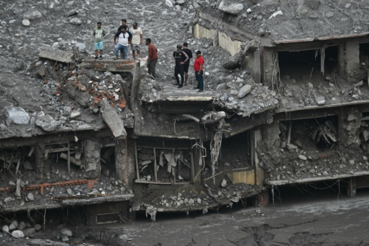 Des habitants sur le toit de maisons endommagées et couvertes de boue au lendemain de crues soudaines à Trishuli, dans le district de Nuwakot, le 6 septembre 2026 au Népal ( AFP / Pedro PARDO )