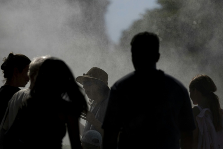 Des personnes sous un système de rafraichissement pendant la canicule à Strasbourg, le 20 juin 2026 ( AFP / ROMEO BOETZLE )