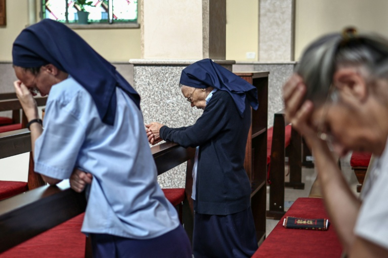 Des catholiques prient pendant une messe dans le village de Taybeh, en Cisjordanie occupée, le 22 juin 2026 ( AFP / Zain JAAFAR )