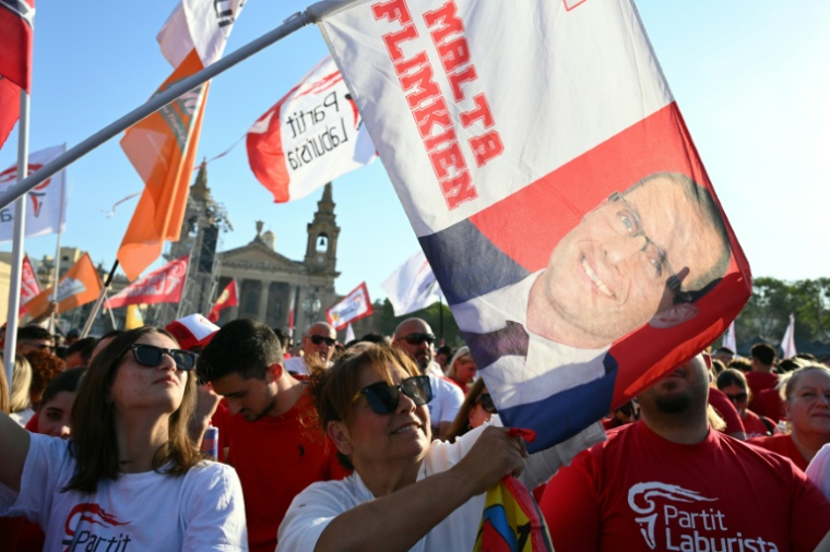 Des partisans du Parti travailliste brandissent un drapeau du Premier ministre de Malte et chef de cette formation, Robert Abela, lors d'un meeting électoral à la capitale La Valette, le 28 mai 2026 ( AFP / Alberto PIZZOLI )